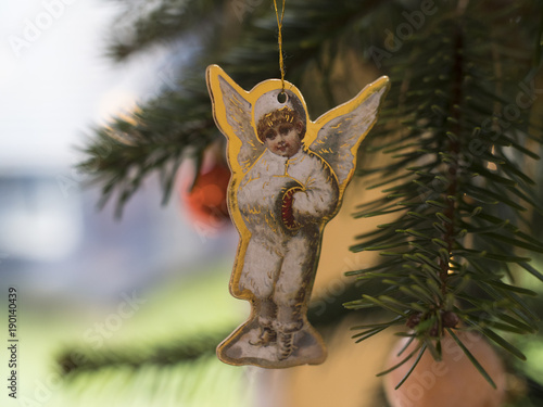 Christmas angel ornament hanging from a christmas tree