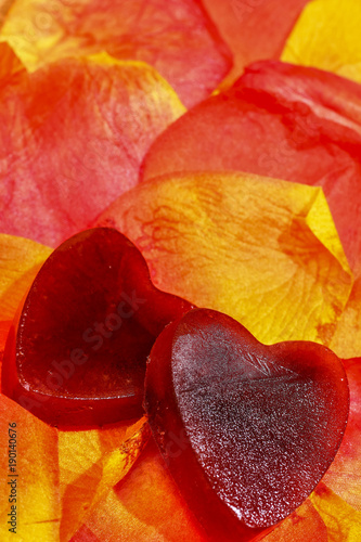 Heart shaped ice on artificial red and yellow petals