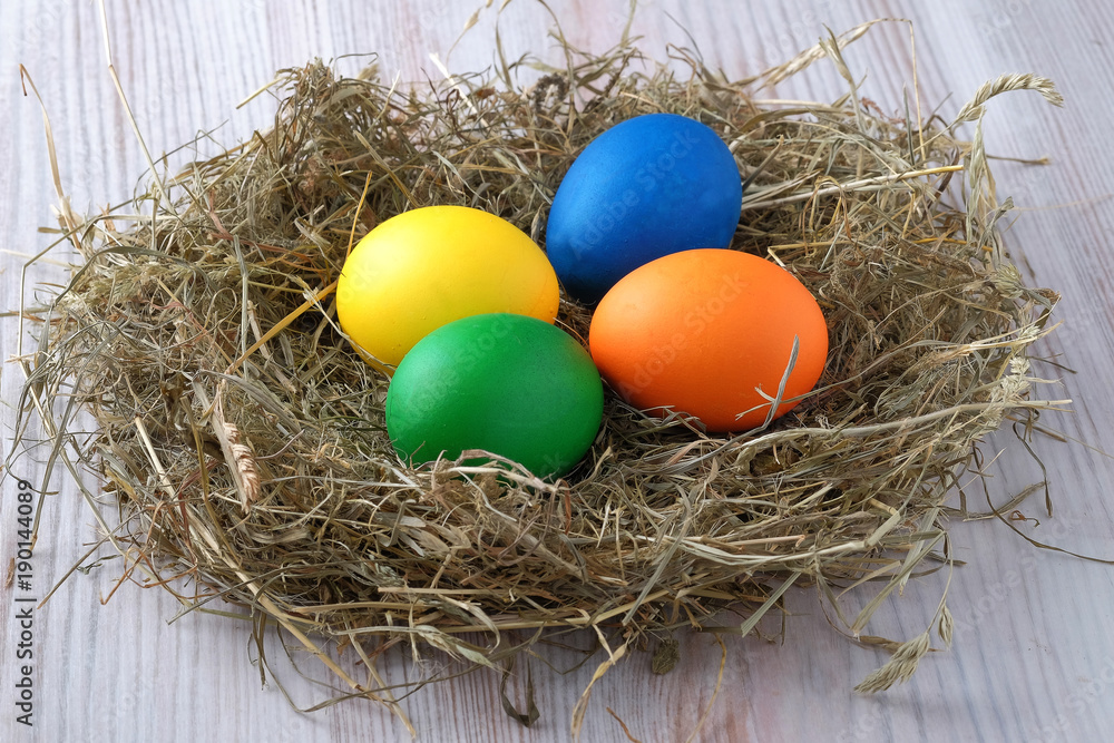 In the nest of hay there are multi-colored Easter eggs. Close up view. In the nest of hay there are multi-colored Easter eggs. Close up view.