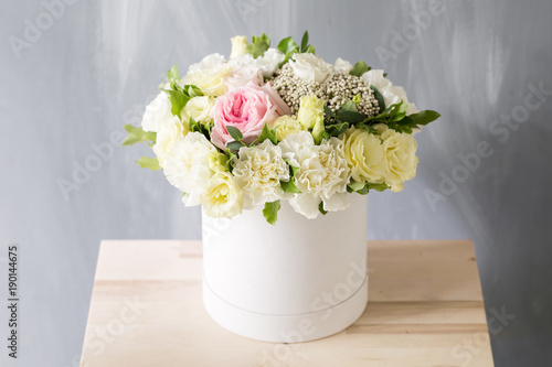 Beautiful tender bouquet of flowers in white box on light ackground with space for text