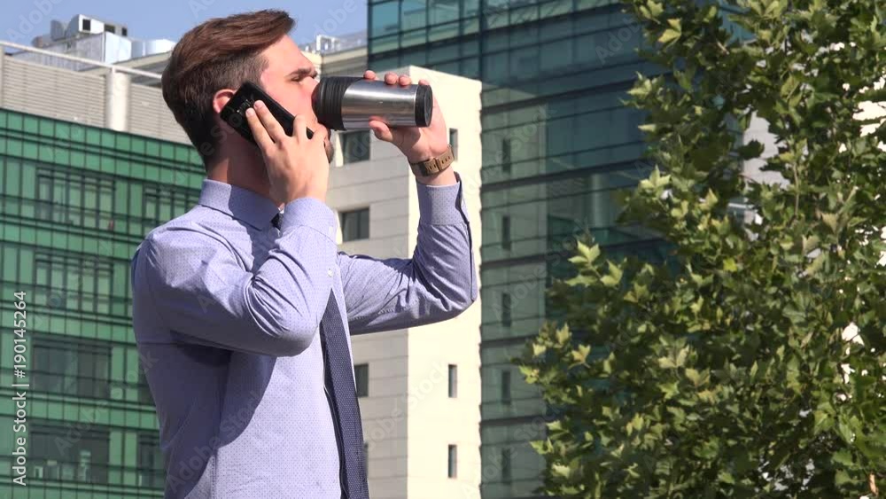 Business man manager entrepreneur talking on phone in the city drinking coffee Business man manager entrepreneur talking on phone in the city drinking coffee