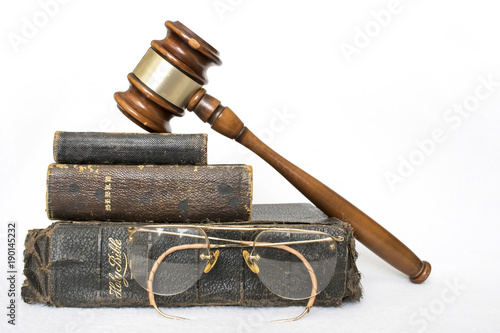 Fotografija Three Antique Worn Leather Bibles with Gavel and Antique Glasses on White Backgr