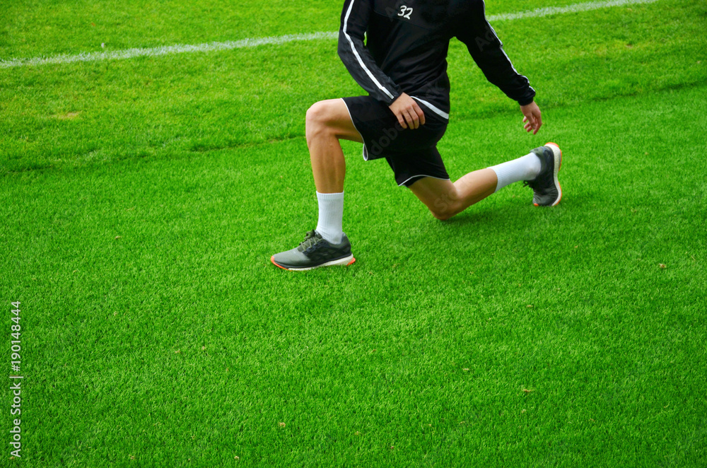 Stretching. Warm up on green grass Stretching. Warm up on green grass