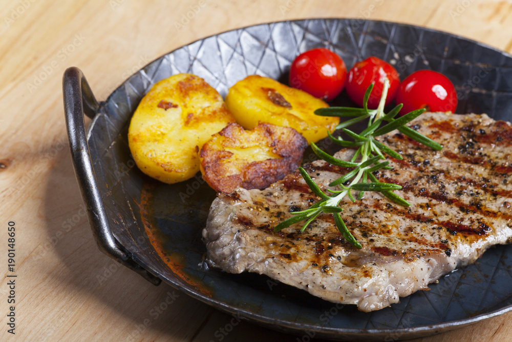 Gegrilltes Steak mit Rosmarin in einer Pfanne Gegrilltes Steak mit Rosmarin in einer Pfanne