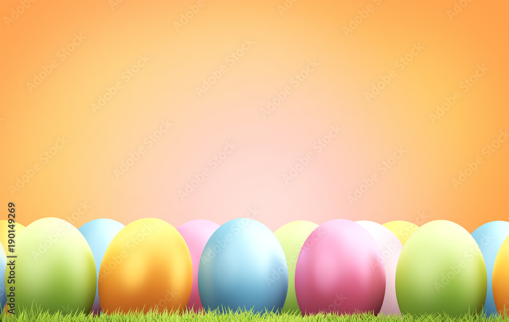 pile of Easter eggs with green blades of green at orange blurred background