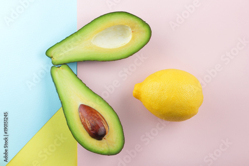 Avocado, lemon and two halves of avocado on a multi-colored background, tropical fruit pop art, vegetarian breakfast, Asian cuisine, avocado pop art, citrus, art