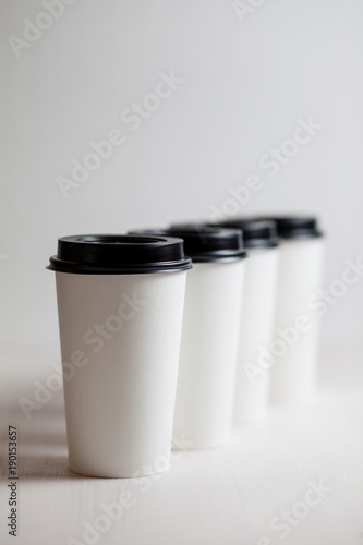 Coffee in blank white paper cups takeaway with caps. on white background.