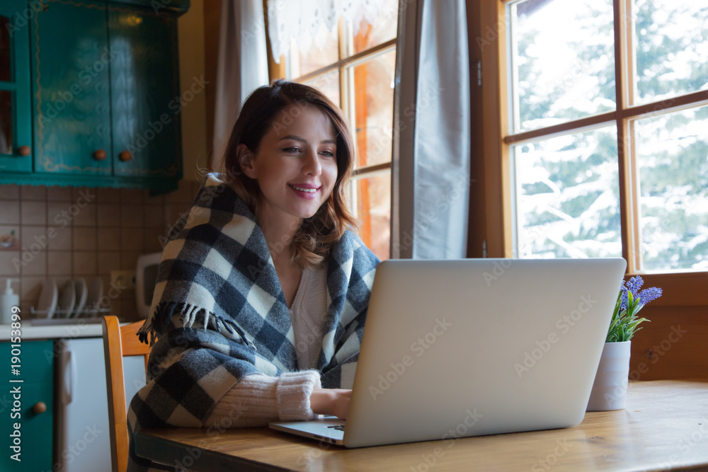 portrait of beautiful redhead girl in plaid sitting at table with computer portrait of beautiful redhead girl in plaid sitting at table with computer