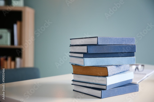 Stack of textbooks on table in student's room. Preparing for exam