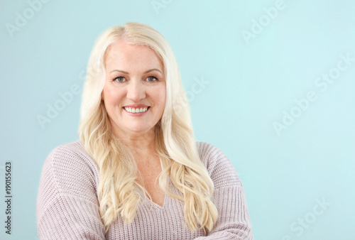 Portrait of mature smiling woman on color background