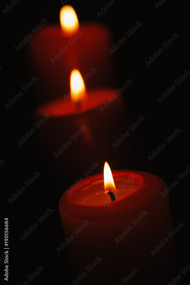 Beautiful candles burning on a black backgrounds Beautiful candles burning on a black backgrounds