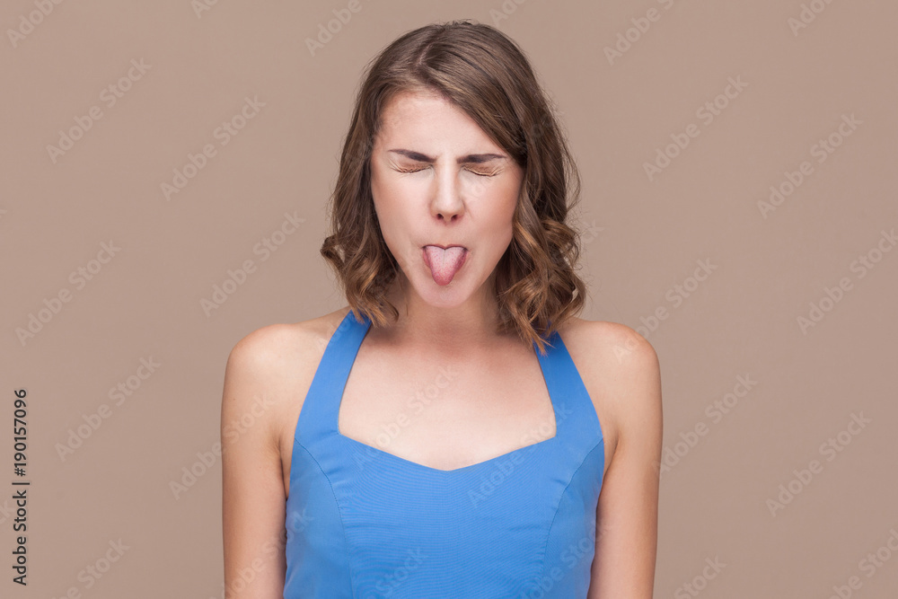 Crazy business woman in blue dress tongue out and closed eyes. Crazy business woman in blue dress tongue out and closed eyes.