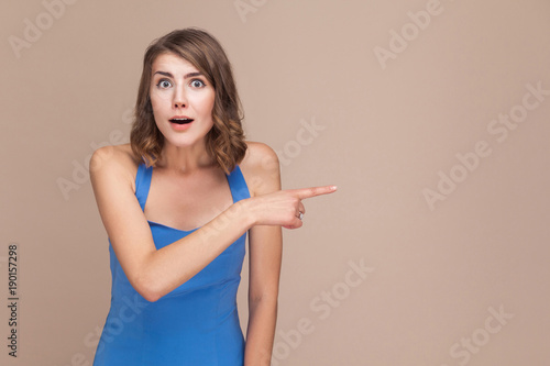 Amazement woman pointing finger at copy space