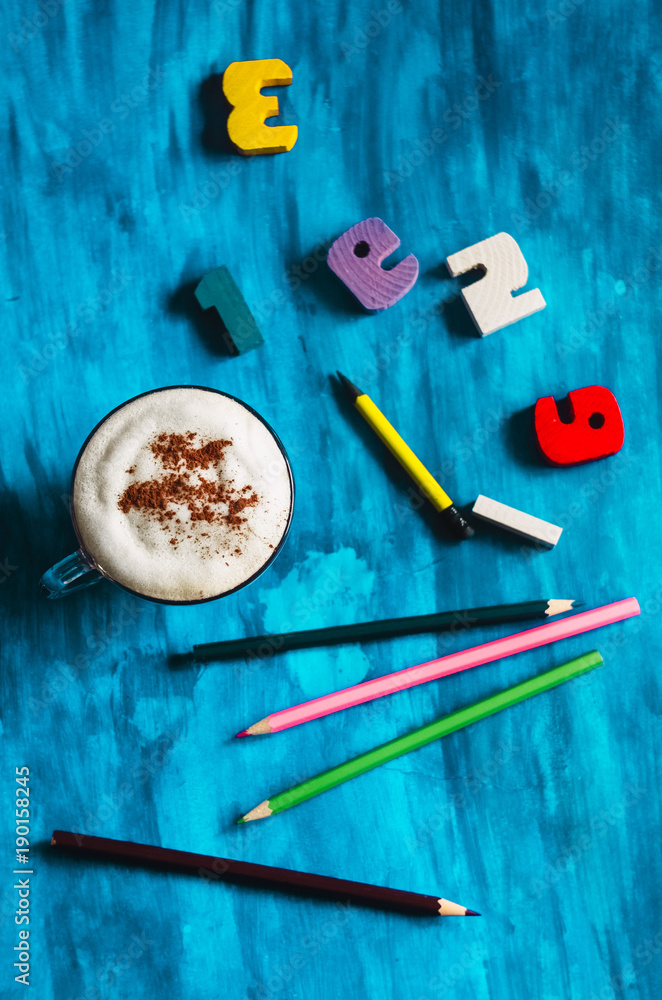 a cup of hot coffee with chocolate. figures with pencils a cup of hot coffee with chocolate. figures with pencils