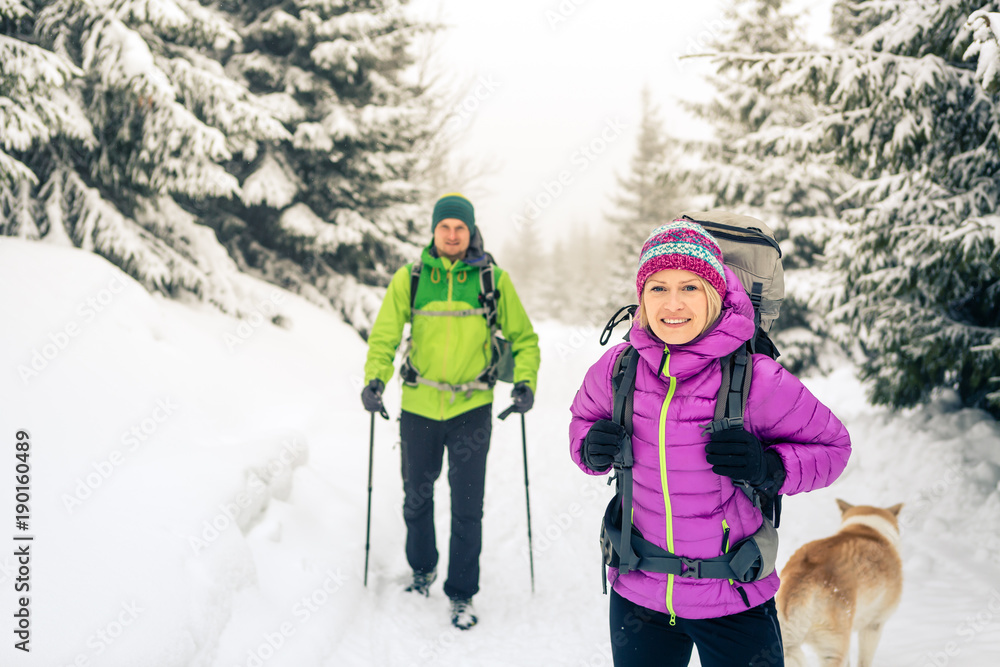 Couple hikers trekking in winter woods Couple hikers trekking in winter woods