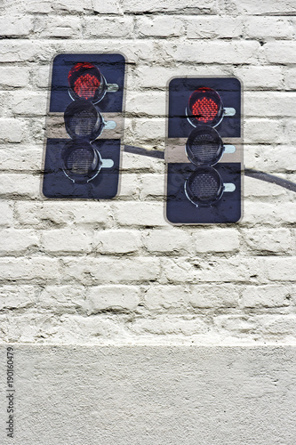 Traffic light stamped on white brick wall