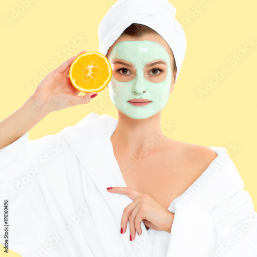 Beautiful woman with clay mask on pastel yellow background. Beauty and spa