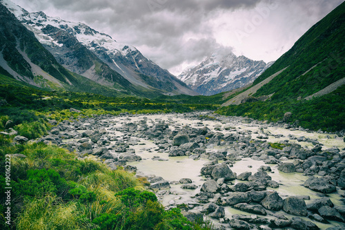Fototapeta Naklejka Na Ścianę i Meble -  Hooker Valley Track hiking trail, New Zealand. River leading to Hooker lake with glacier over view of Aoraki Mount Cook National Park with snow capped mountains landscape. Summer nature.