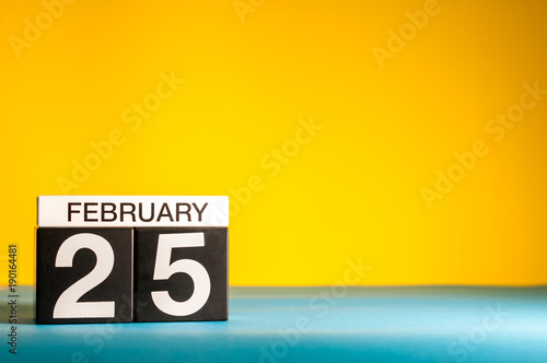 February 25th. Day 25 of february month, calendar on yellow background. Winter time. Empty space for text