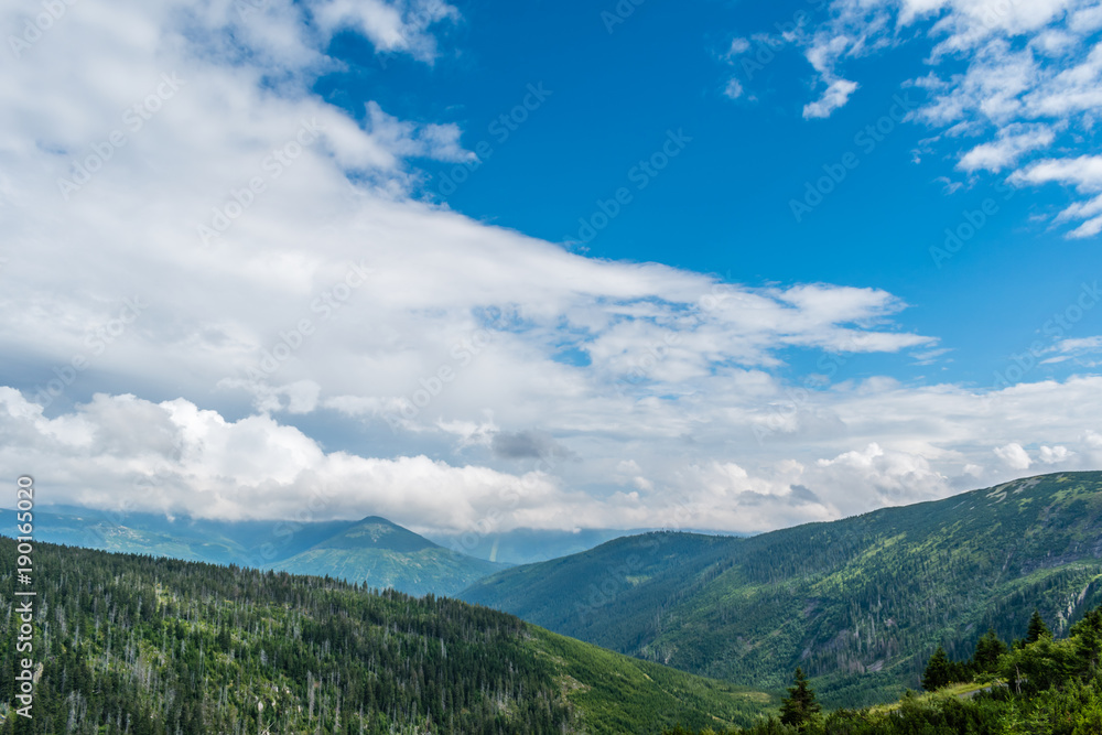 Beautiful view from mountains to the horizon with mountains and green valley with trees and forest