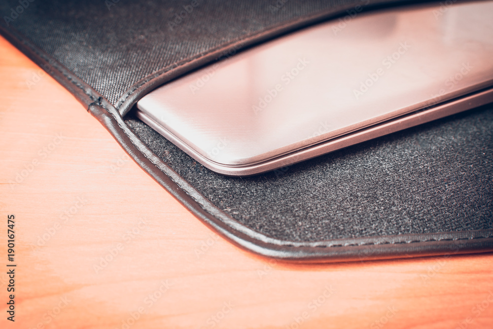 Ultra thin laptop in a bag on the desk Ultra thin laptop in a bag on the desk