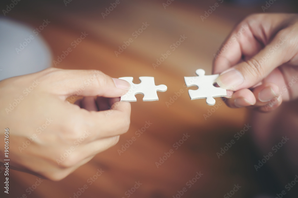 Hand holding jigsaw puzzles, Business partnership concept.