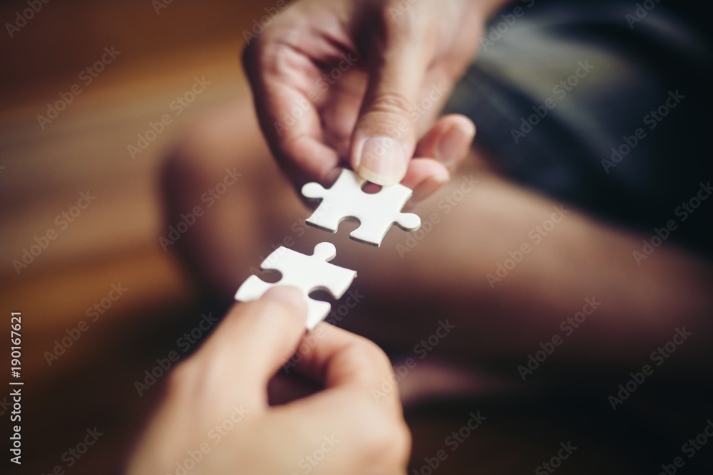 Naklejka premium Hand holding jigsaw puzzles, Business partnership concept.