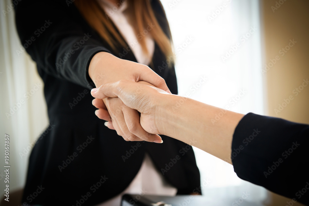 Business people shaking hands while sitting at the working place, Finish success business good deals meeting Business people shaking hands while sitting at the working place, Finish success business good deals meeting