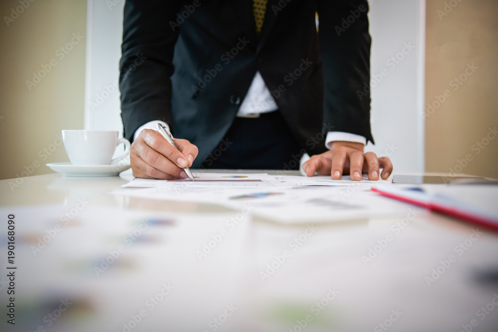 Serious businessman working on documents looking data and planning business on table. Serious businessman working on documents looking data and planning business on table.