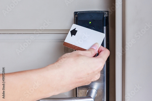 Hotel door - Close up of hand young man holding a keycard in front of the electronic sensor of a room door