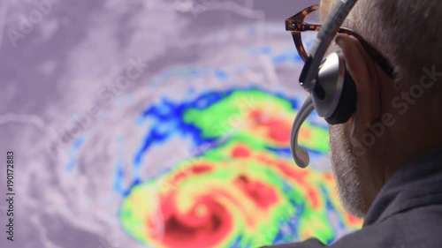 Weather man tracking a tropical storm on  computer screen