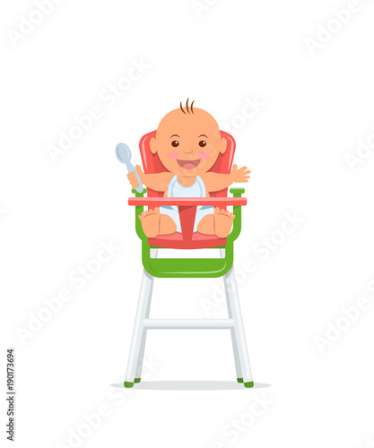 Cute baby sits on a high chair and holds a spoon. Baby healthy feeding concept.