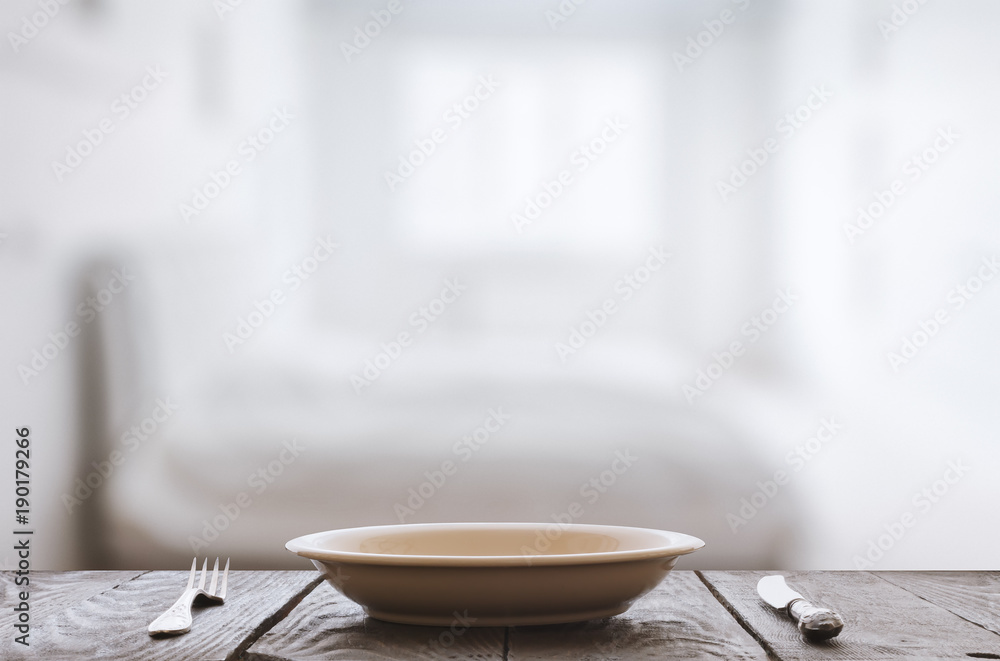 empty plate with fork and knife on wooden table empty plate with fork and knife on wooden table