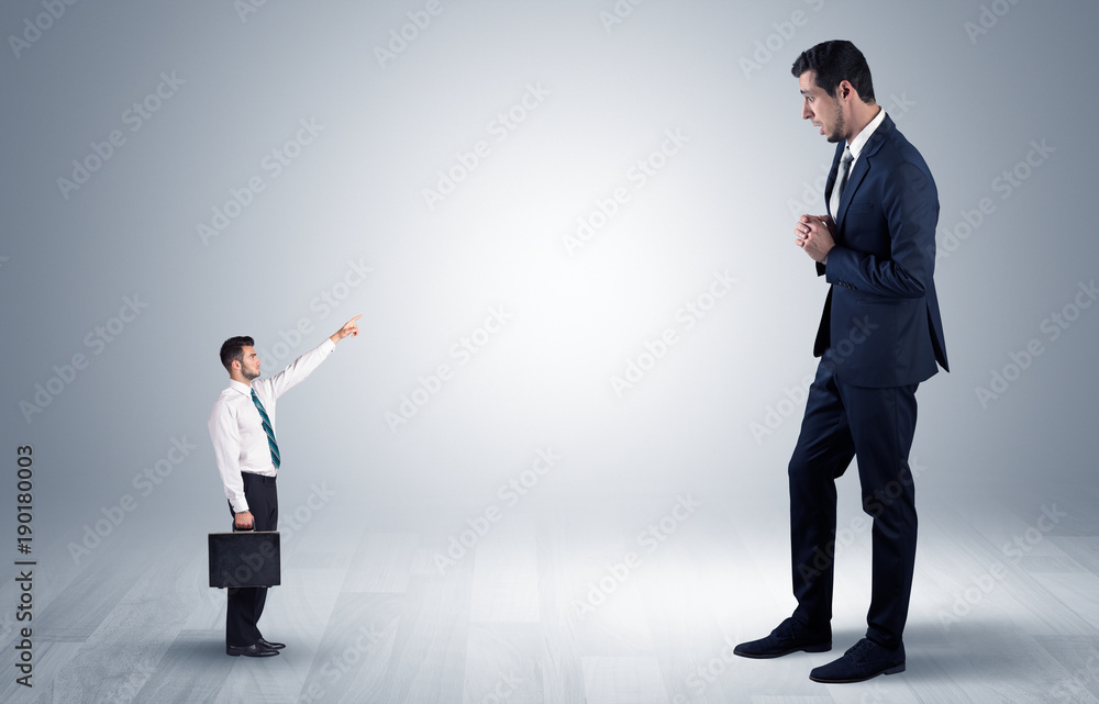 Small businessman pointing to a giant businessman Small businessman pointing to a giant businessman