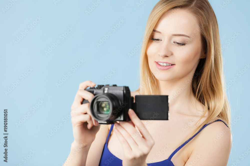 Blonde woman with camera on blue Blonde woman with camera on blue