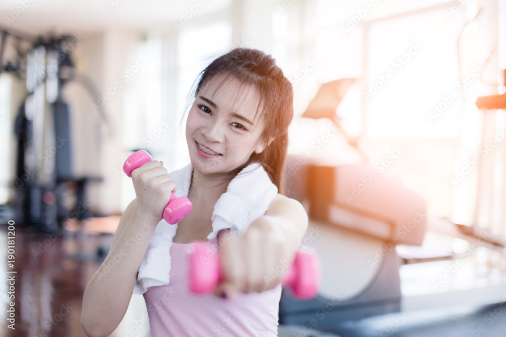 beautiful and smart healthy asian young woman smile while workout at gym fitness center with blur background beautiful and smart healthy asian young woman smile while workout at gym fitness center with blur background