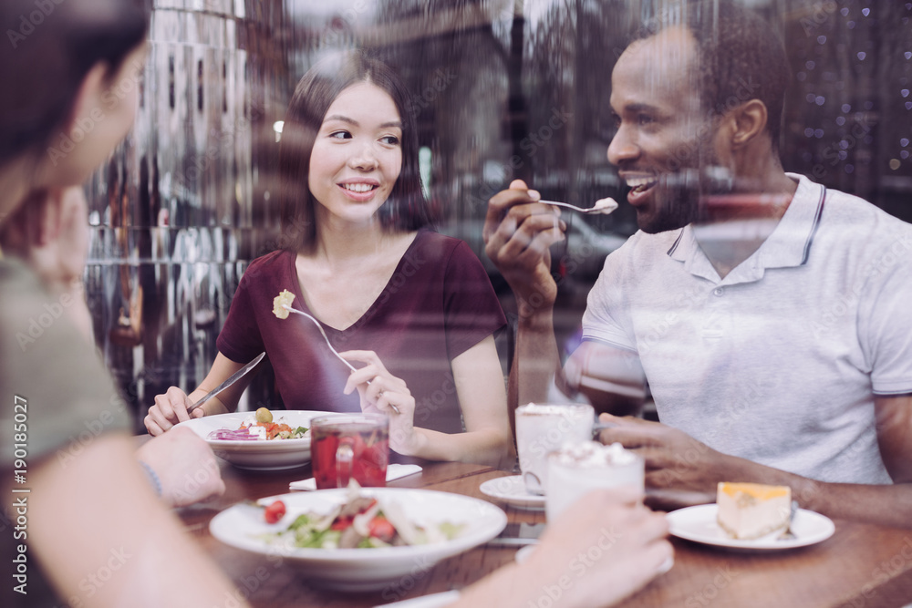 Valuable friendship. Positive nice two friends carrying fork while grinning and enjoying meal Valuable friendship. Positive nice two friends carrying fork while grinning and enjoying meal