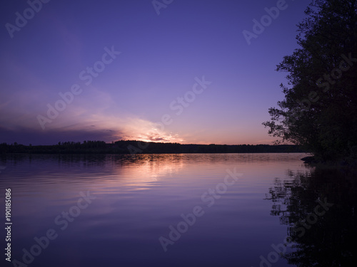 Solnedgång över sjö i Sverige. Fotograferad från båt på sommaren © KarlJohan