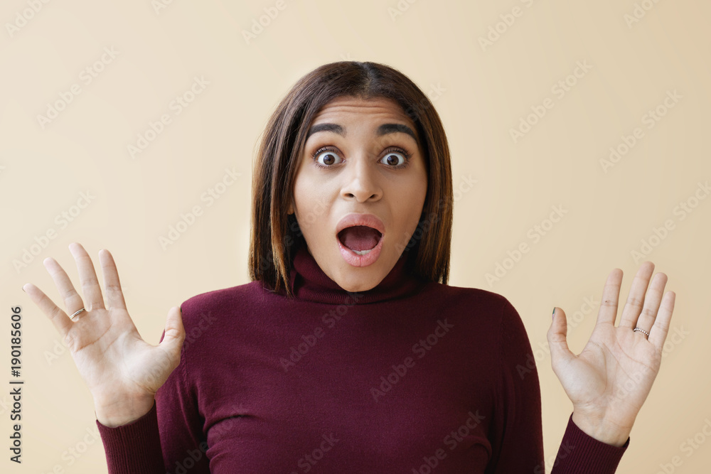 It`s unbelievable! Studio portrait of stunned emotional young dark skinned female staring at camera in full disbelied with eyes popped out and jaw dropped, reacting on unexpected shocking news It`s unbelievable! Studio portrait of stunned emotional young dark skinned female staring at camera in full disbelied with eyes popped out and jaw dropped, reacting on unexpected shocking news