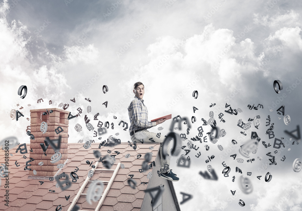 Man on brick roof reading book and symbols flying around Man on brick roof reading book and symbols flying around
