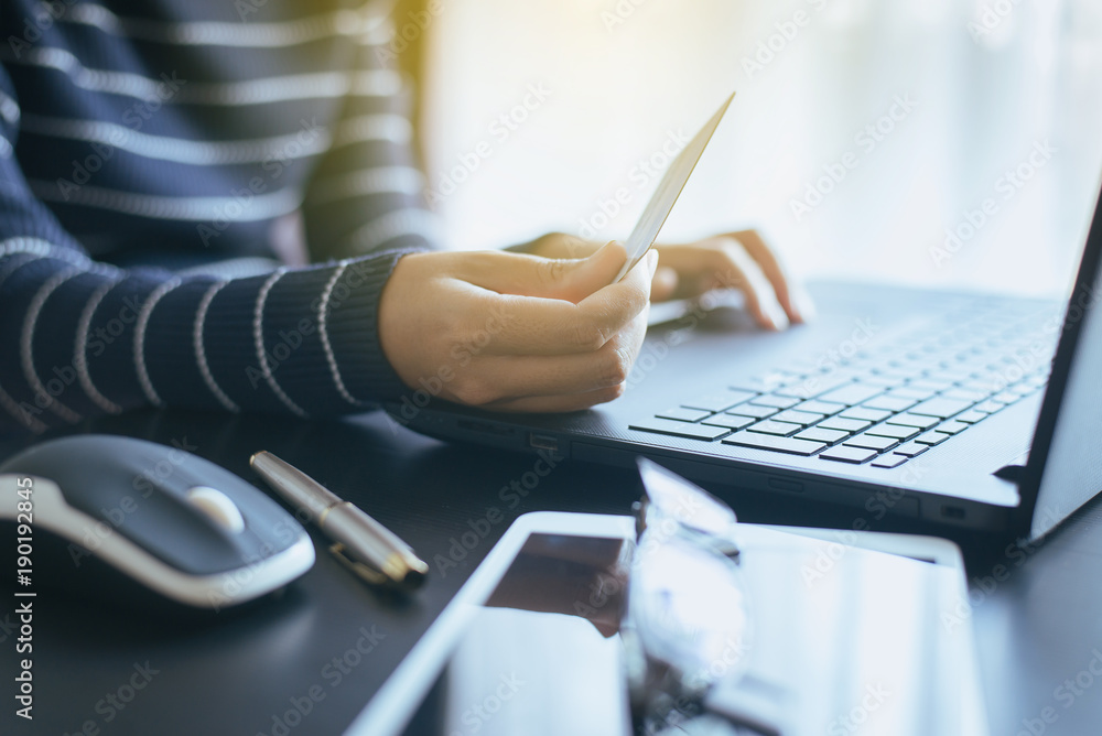 Naklejka premium Close up of hand woman holding credit card and using laptop for online shopping concept