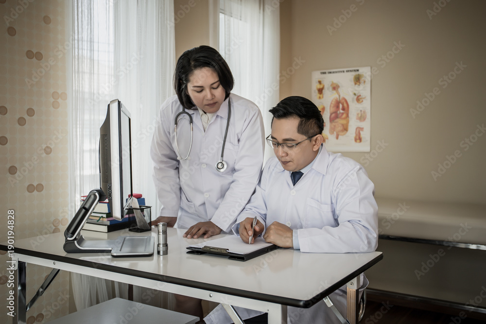 Group of doctors looking at computer on meeting at hospital ward. Group of doctors looking at computer on meeting at hospital ward.