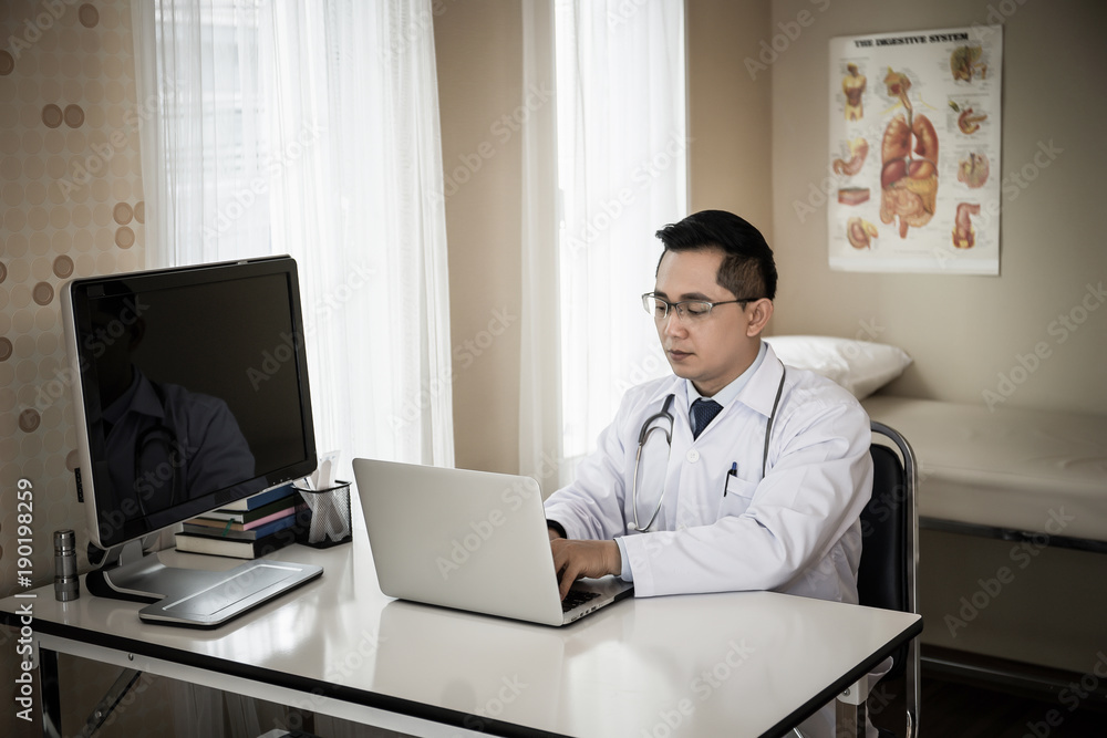 Close up of Medical doctor working with laptop in the office.