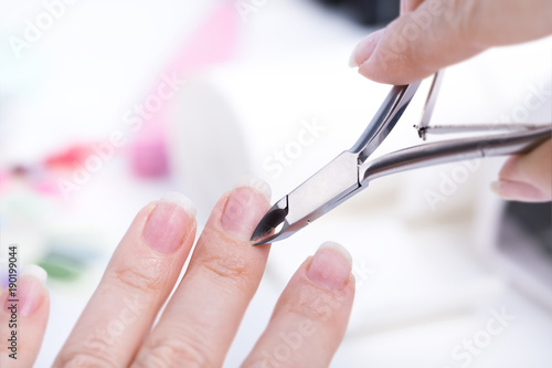 Woman doing manicure with tweezers