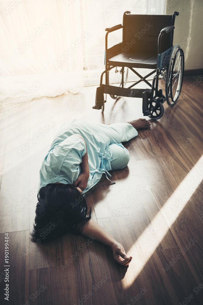 Female patients fall unconscious from a wheelchair on the floor. Heart attack, patients do not help themselves.