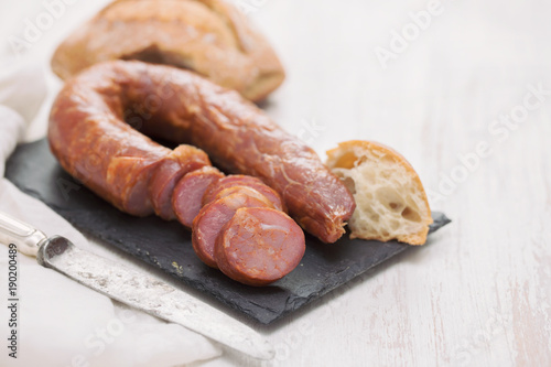 smoked sausages with bread on black ceramic board