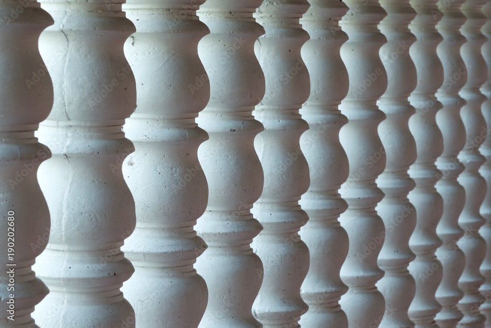 Several white curved columns in one row. Architectural detail of the interior