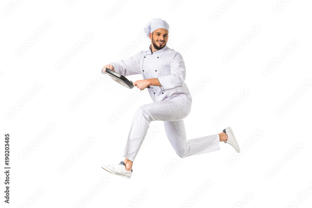 smiling chef with frying pan jumping and looking at camera isolated on white smiling chef with frying pan jumping and looking at camera isolated on white