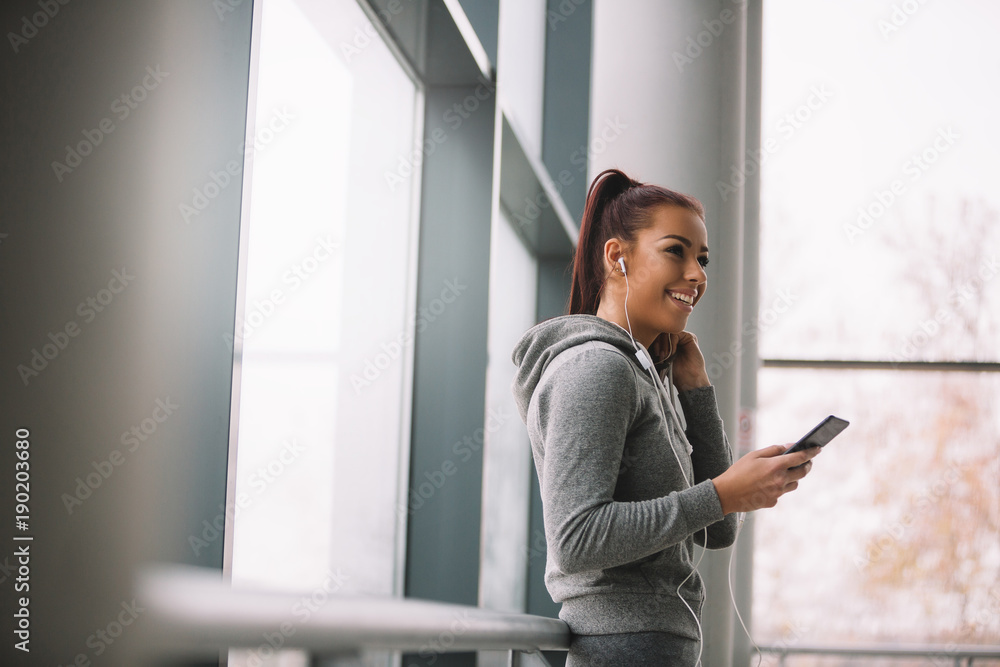 Sporty woman using smart phone after running. Sporty woman using smart phone after running.
