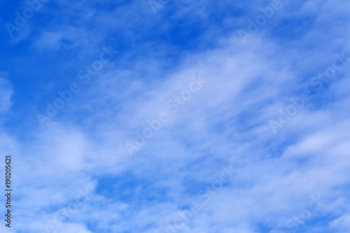 Light blue sky with clouds, may be used as background .